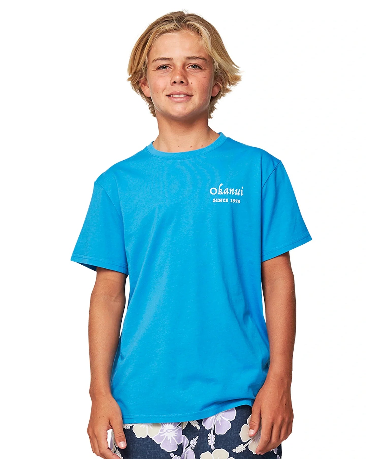 Close up front view of a boy wearing the Okanui Kids Bay Tee T-shirt in Washed Blue
