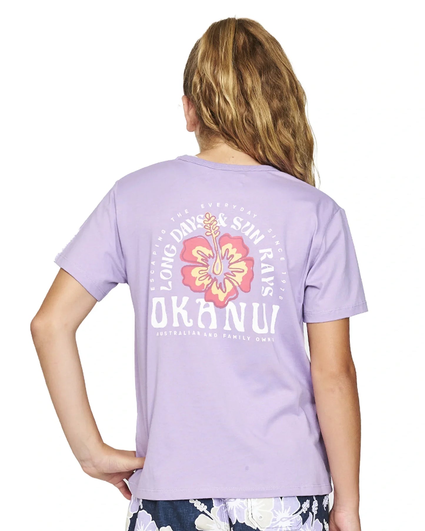 Closeup back view of a girl wearing the Okanui Long Days Tee T-shirt in Lilac