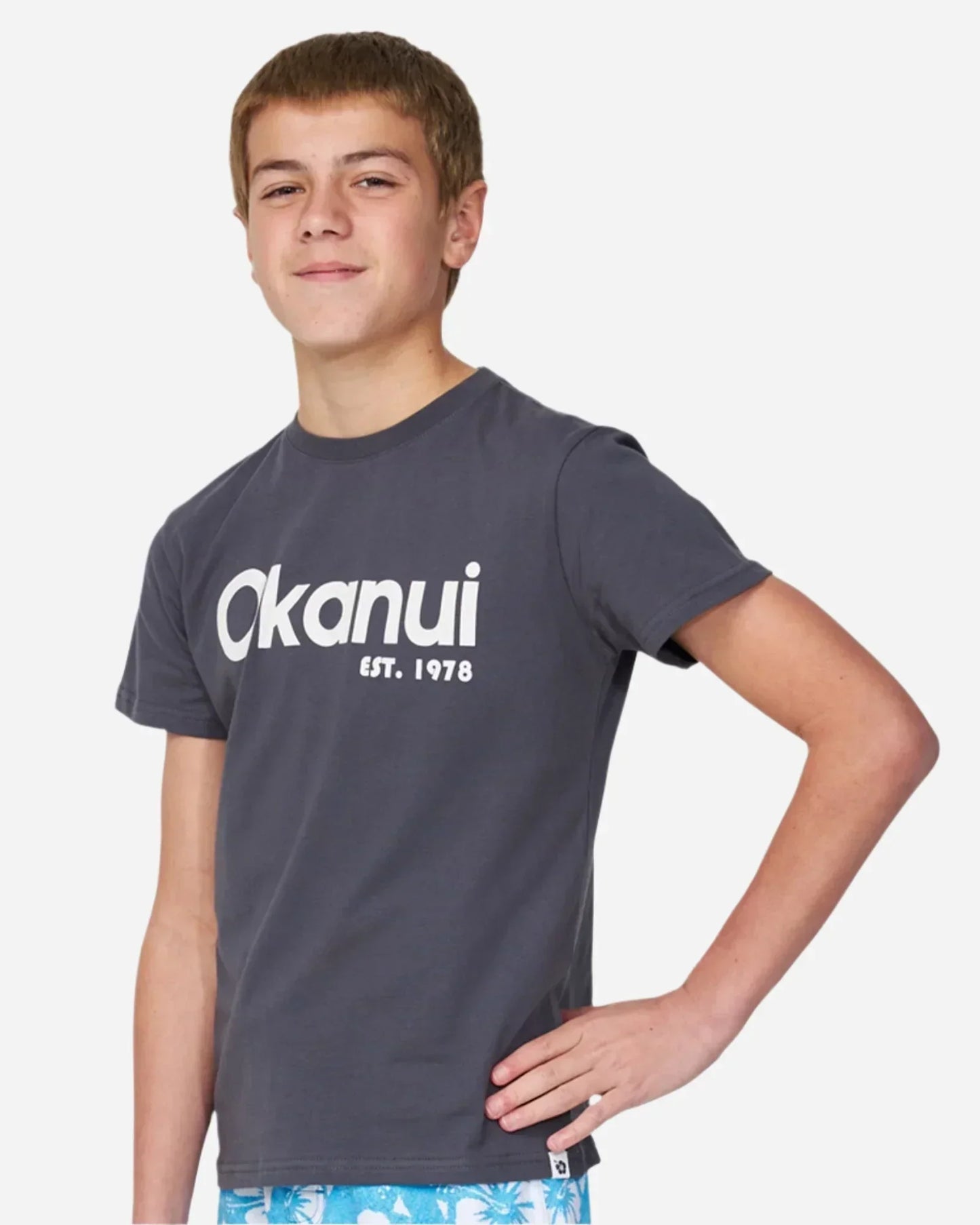 Close up view of a boy wearing the Okanui Logo Tee T-shirt in Washed Black