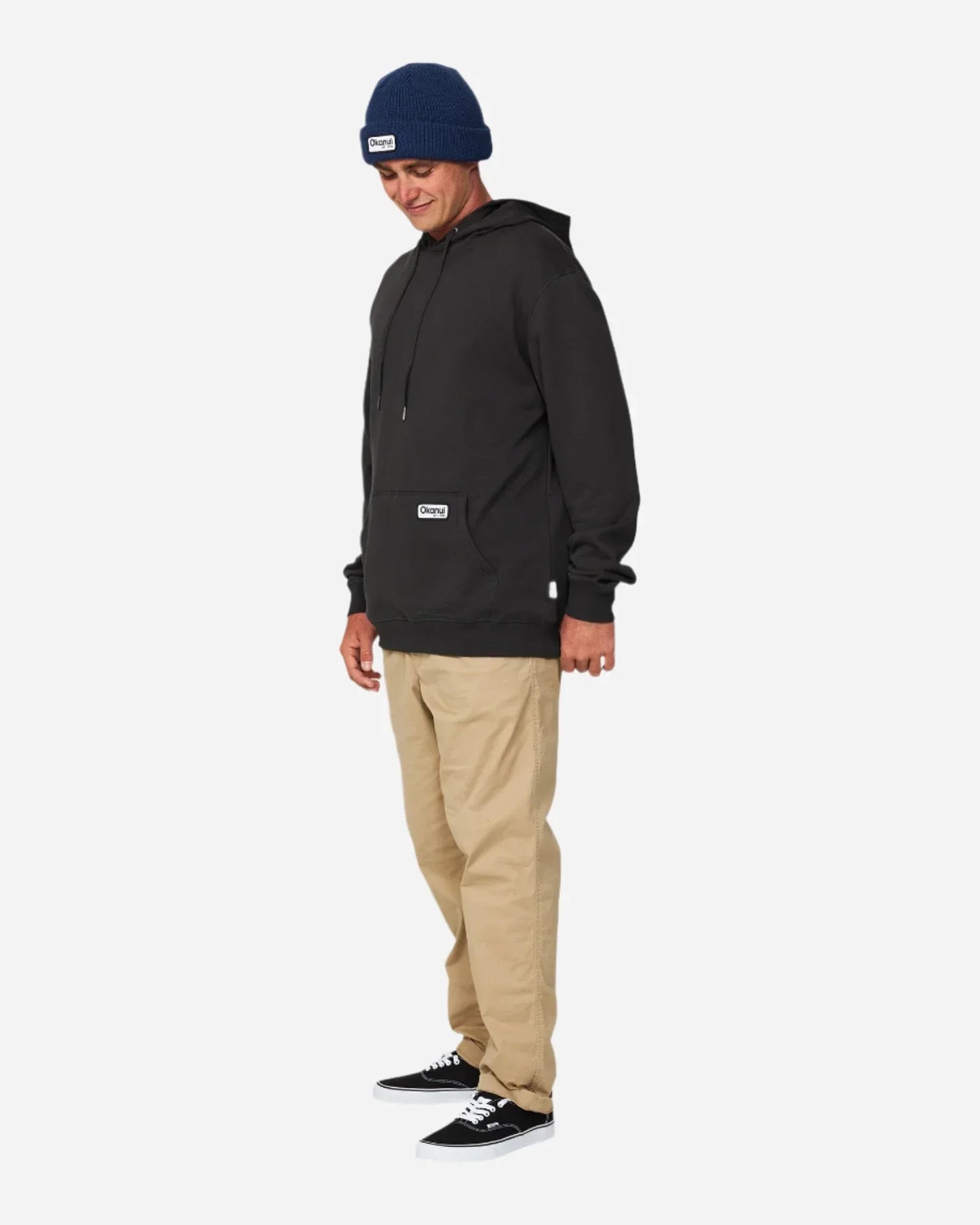 Full body of a male model wearing a long sleeve shirt with hood paired with Okanui Fishermans Rib knit beanie hat in Navy