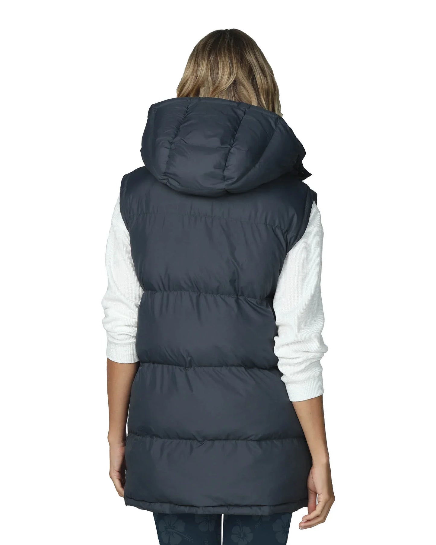 Full body back view of a female model wearing the Okanui puffe jacket vest in Navy