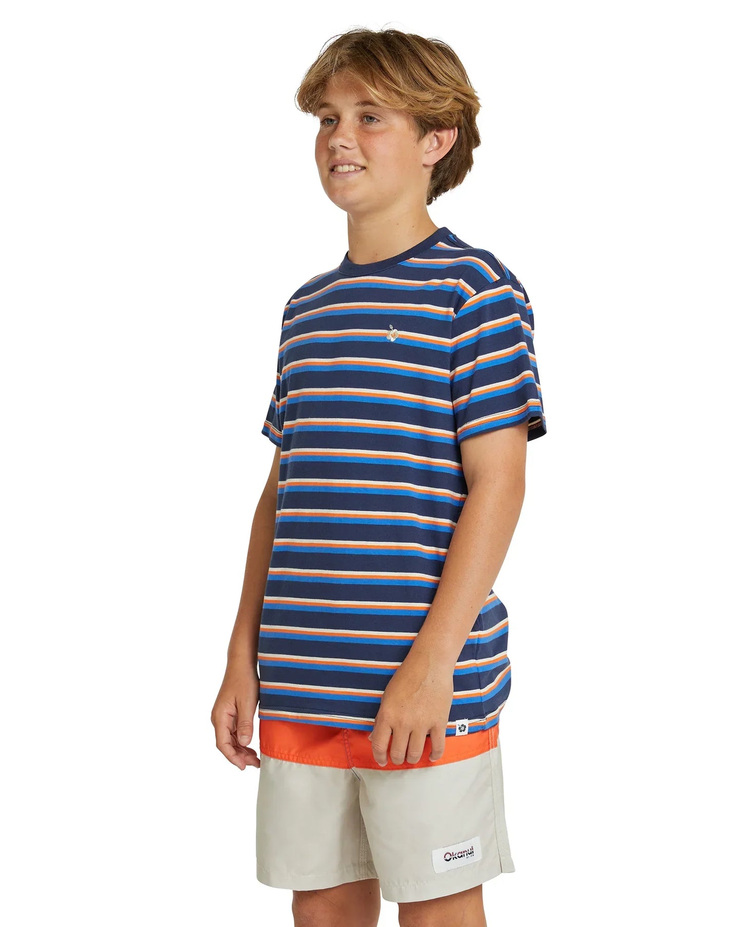 Angled view of a boy wearing the Okanui staple stripe tshirt in Navy/Blue variant. Made from 100% premium cotton in a straight hemline cut