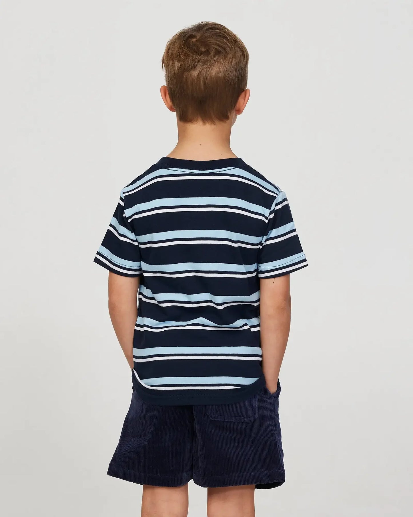 Close up back view of a little boy model wearing the Okanui Corduroy Walk Short in Iron Navy