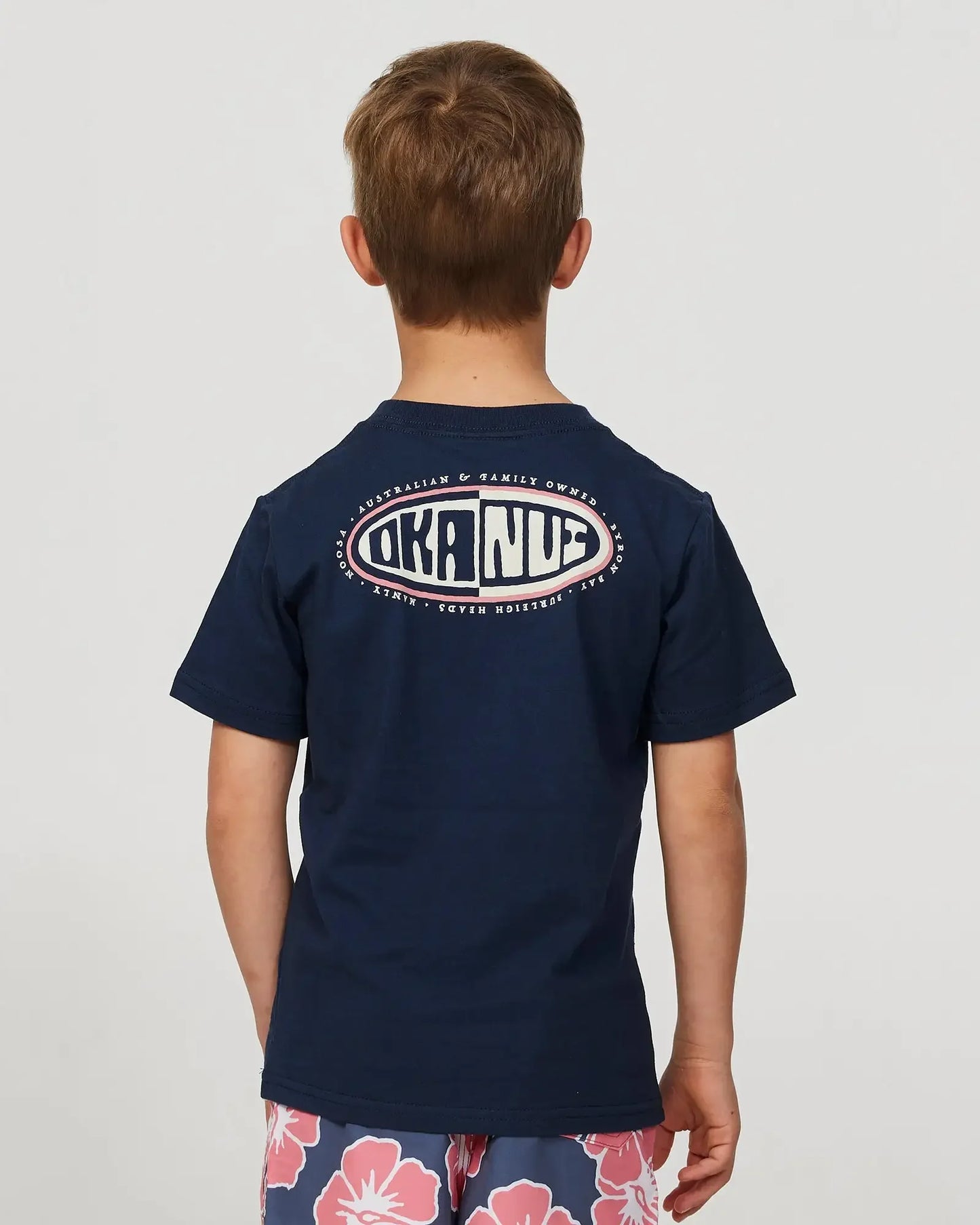 Close up back view of a little boy wearing the Okanui Desch T-shirt for boys in Navy