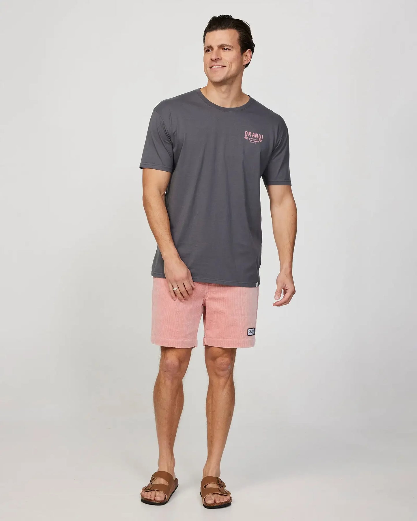 Full body front view of a male model wearing the Okanui Mens Stampede Tee T-shirt in Washed Black