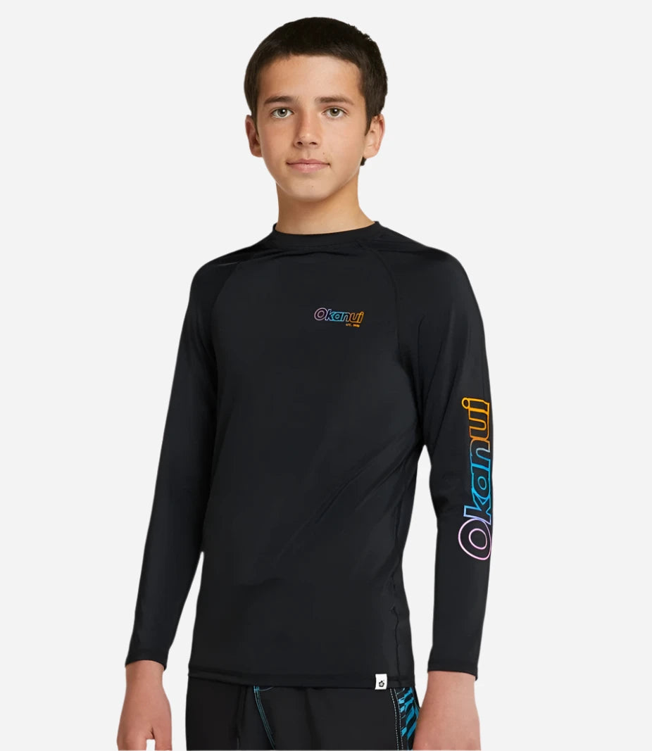 The Okanui Boy's spring long sleeve rashie in black with rainbow print.