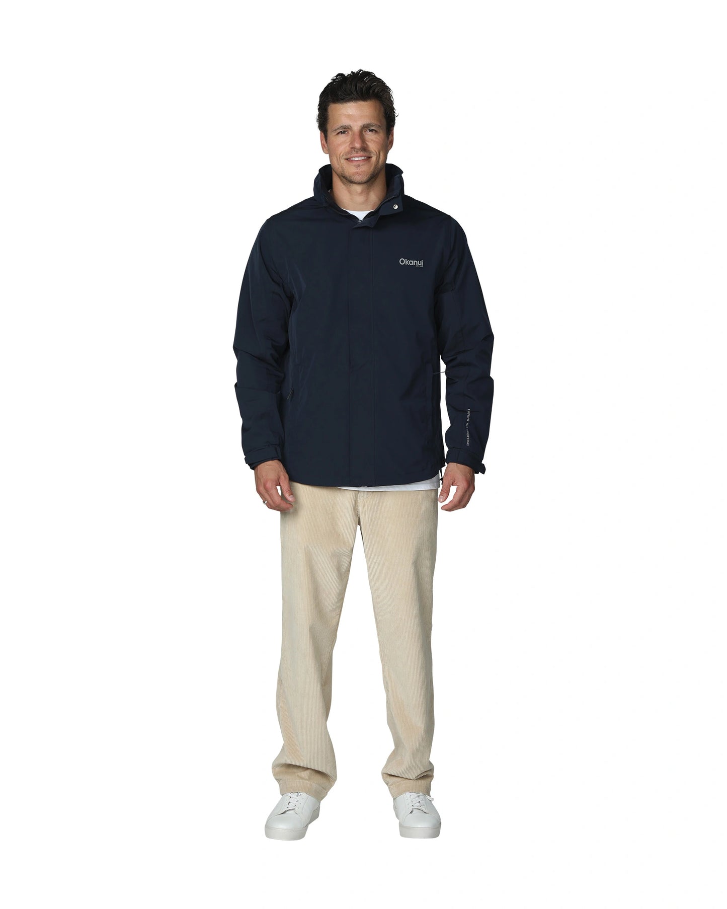 Mens surf jacket in navy blue with beige color pants and white sneakers. 