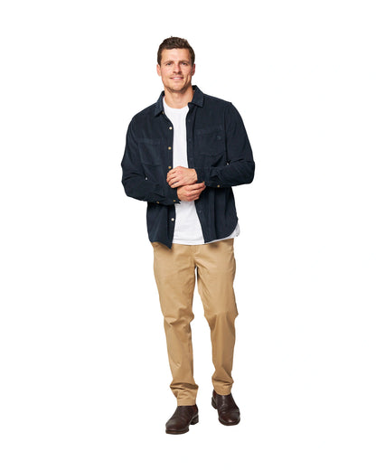 A front view of the Okanui Corduroy Ledge Long Sleeve Shirt in Navy colour paired with an inner white t-shirt and khaki pants and black shoes.