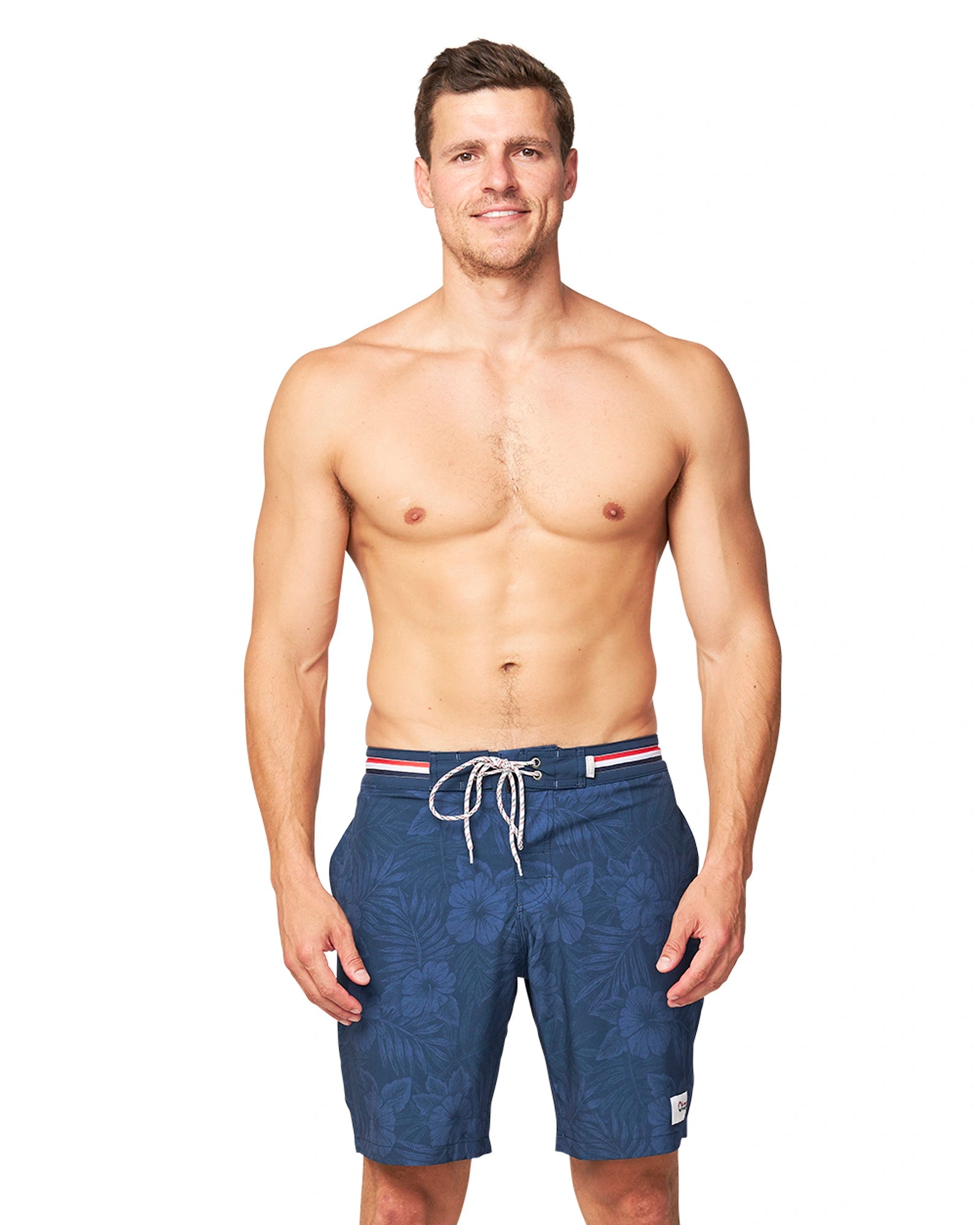 Front view of a model wearing the wearing the Okanui Midnight Jungle Boardrider Boardshort in navy color.