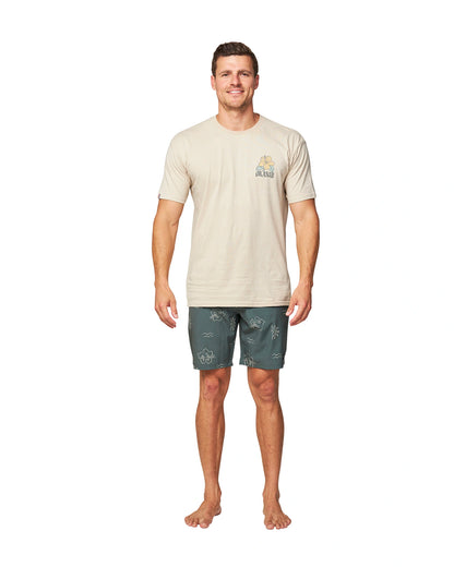 A male model wearing a white t-shirt and the Okanui Rising Sun Boardrider Boardshort in Forest color.