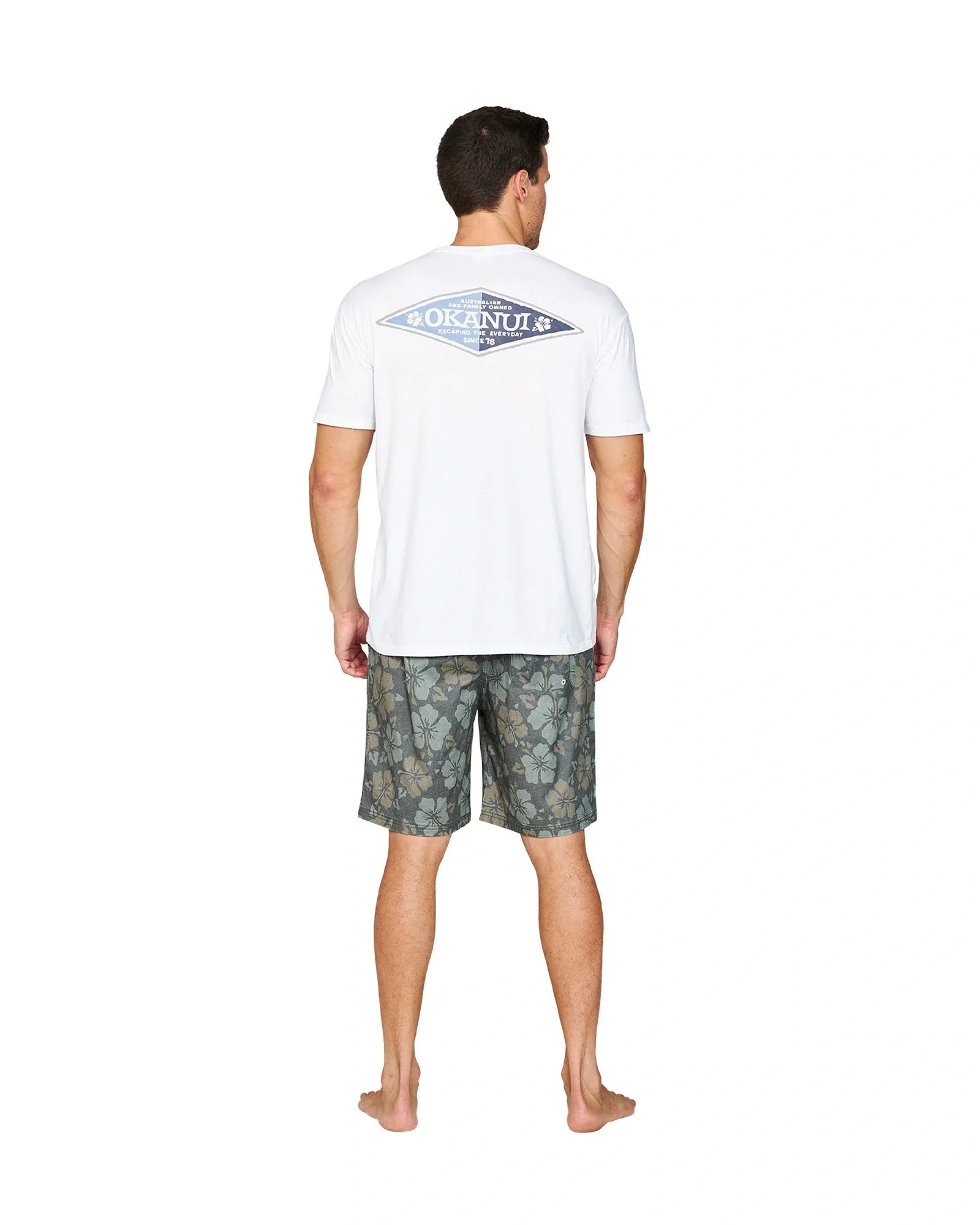 A full body back view of a model wearing the Okanui Stonewall Heritage Walk Short in Forest colour.