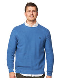 A male model wearing the Okanui Anchor Knit in Blue Marle color.