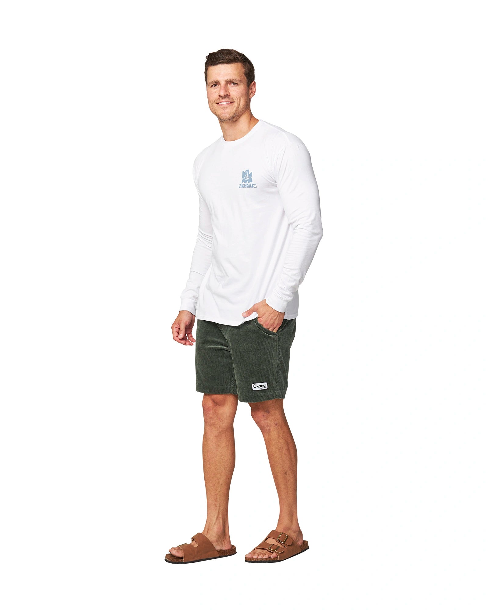 Full body front view of a male model with his hand in his pocket, wearing the Okanui Jungle long sleeve t-shirt in White color