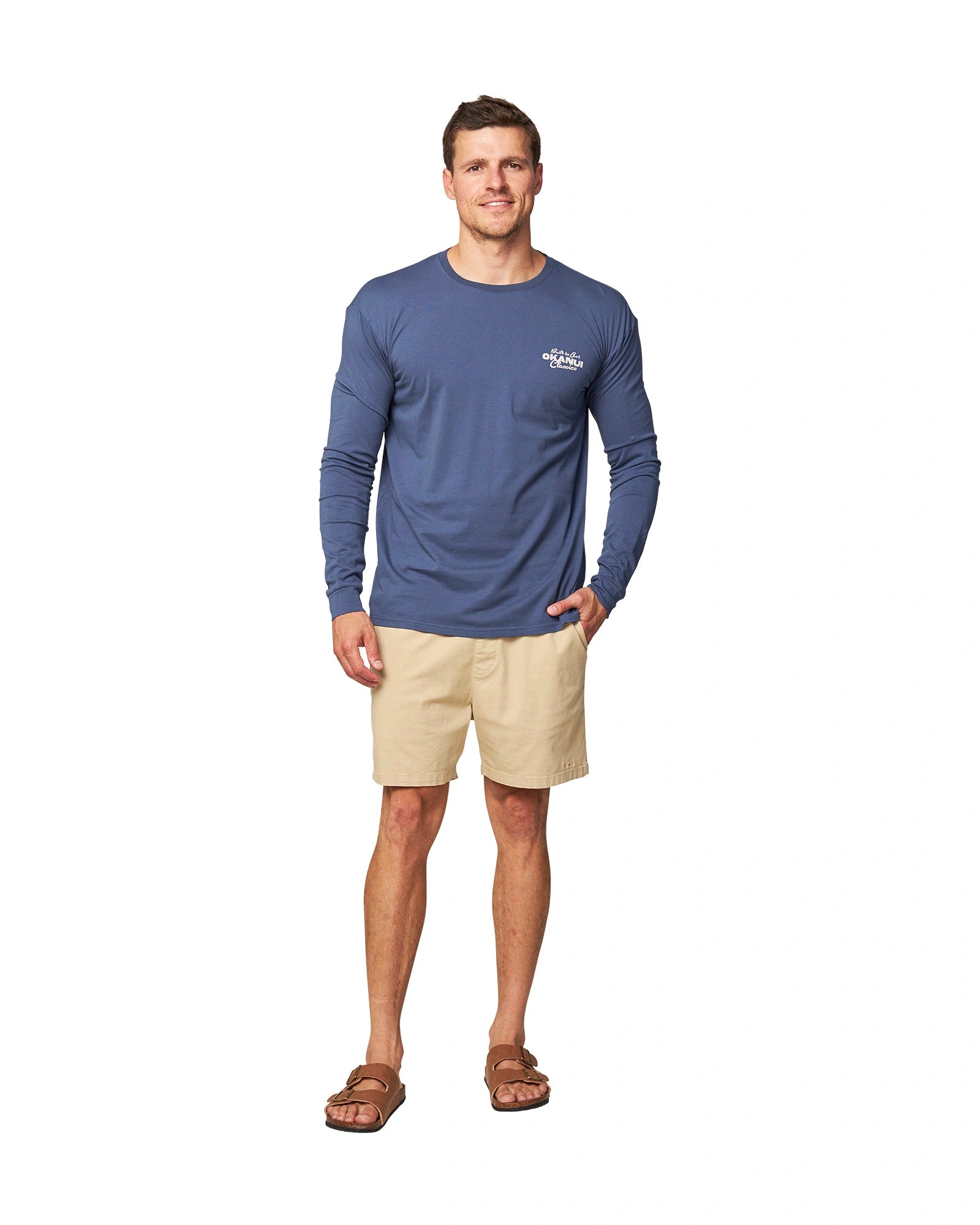 Full body front view of a male model wearing the Okanui Last Stand long sleeve t-shirt in Washed Navy color, crafted from premium cotton