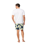 One hand in pocket pose of a male model wearing a white top shirt and Okanui Way Back When stretch swim shorts in Navy Lime