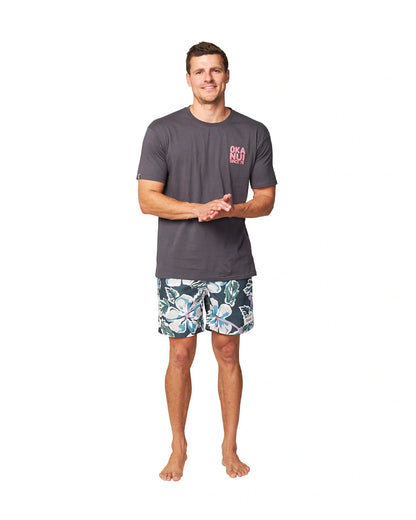 A male model wearing a dark grey t-shirt and the Okanui Flora Fatigue Swim Shorts.