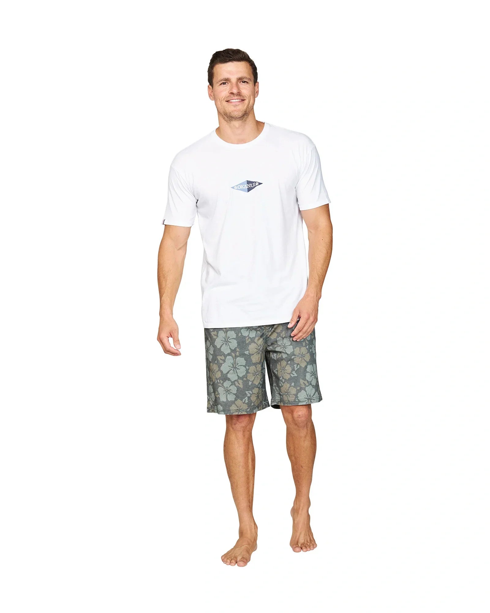 Front view of a male model casually posing wearing the Okanui Cornerstone T-shirt in white colour.