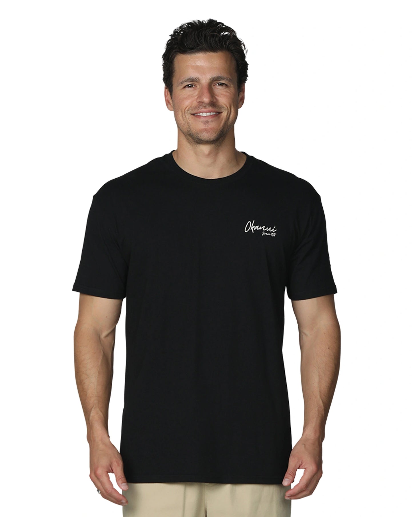 A close up front view of a male model wearing the Okanui's Island Nights T-Shirt in Black colour featuring the chest logo on the left side.