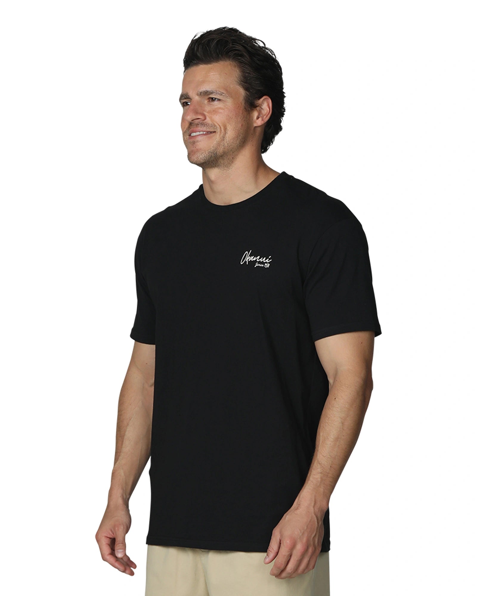 A male model slightly side front view wearing the Okanui's Island Nights T-Shirt in Black colour.