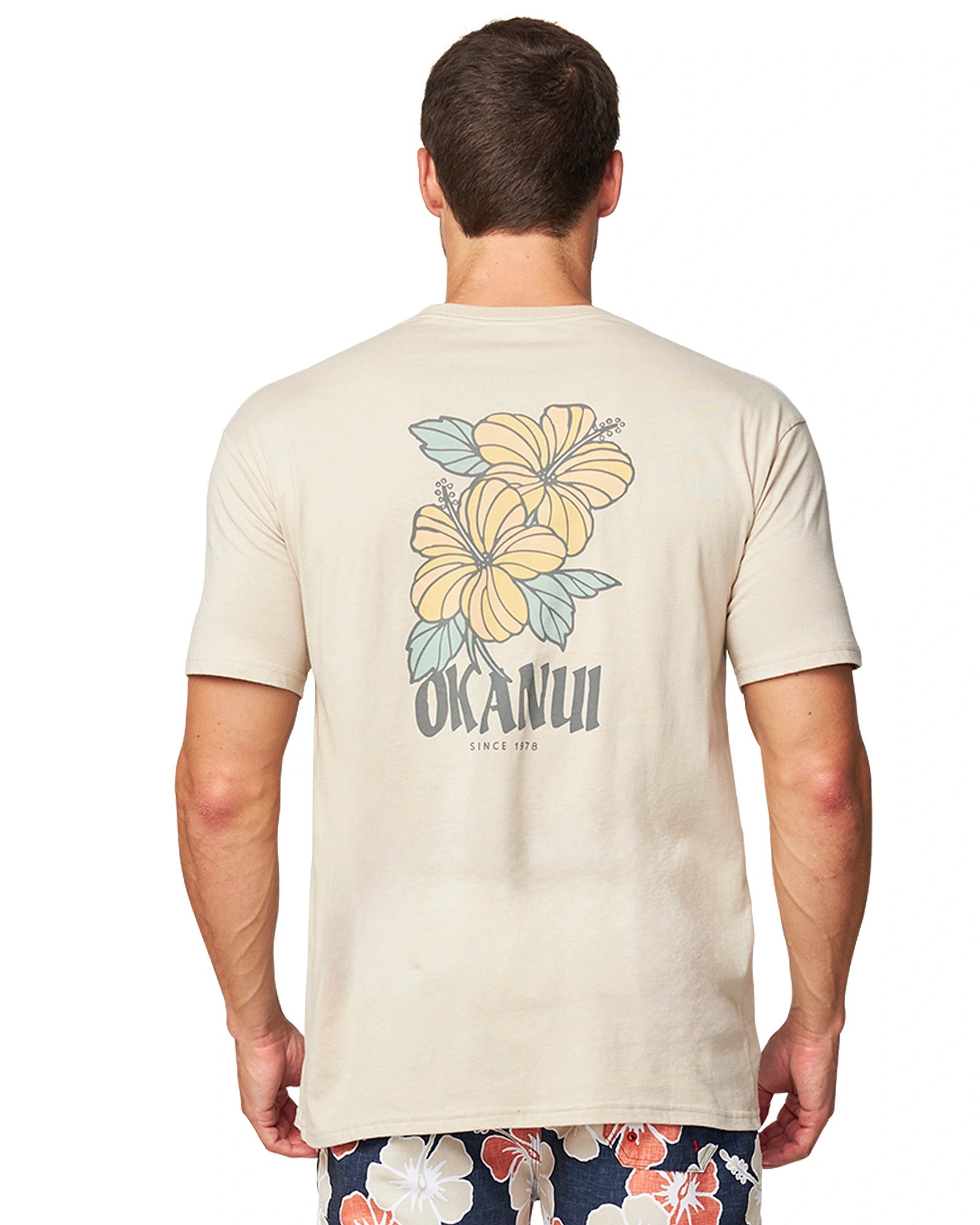 A close back view of the  Okanui Look Both Ways T-Shirt in stone colour.