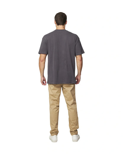 Front back view of the Okanui Men's Cube Heavy Weight Tee in Washed Iron colour paired with khaki pants and white shoes.