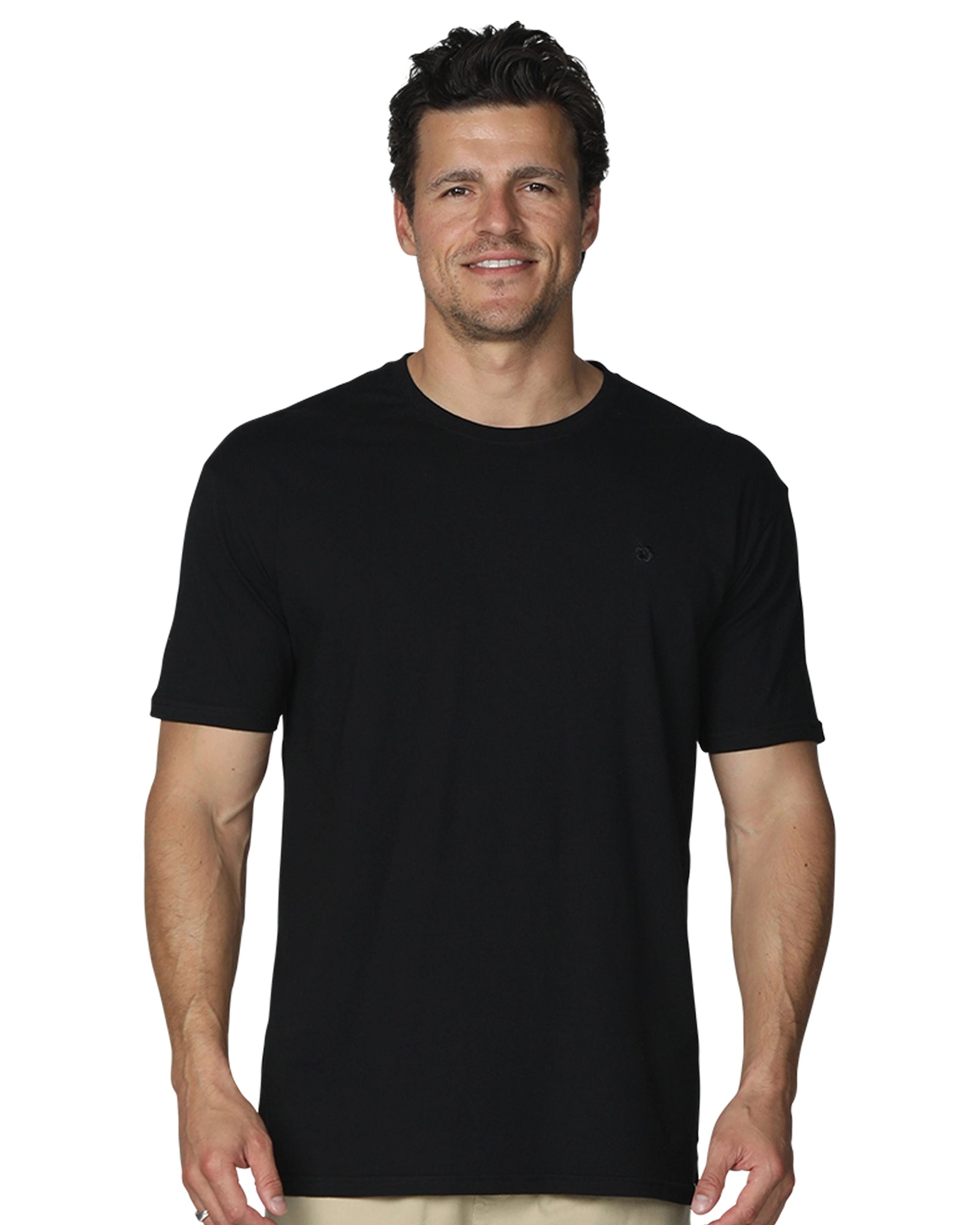 A close up front view of a smiling male model wearing the the Okanui Mens Staple Tee in Black colour.