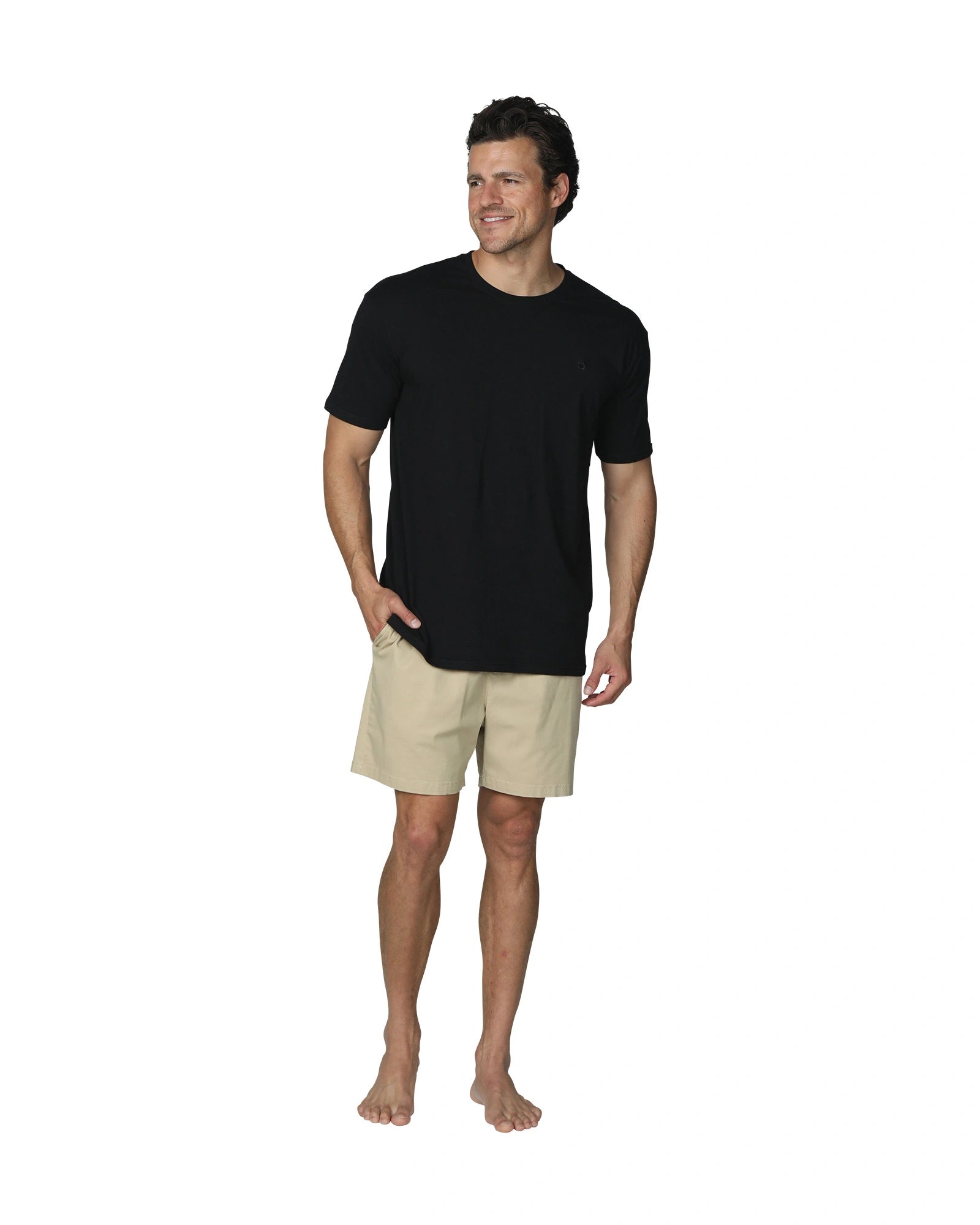 A full front view of a male model with his hand in his pocket wearing the the Okanui Mens Staple Tee in Black colour.