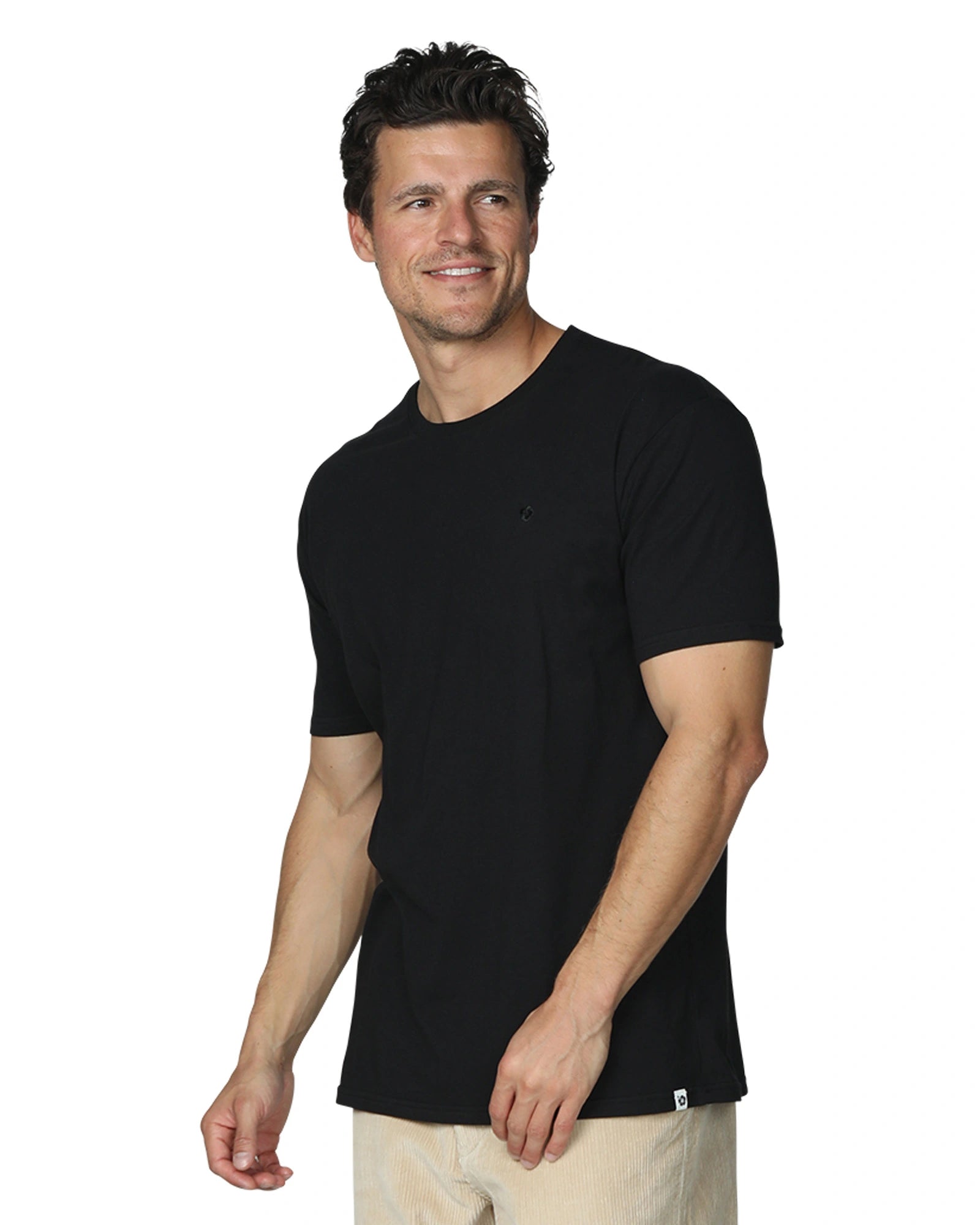 A casual pose of a male model wearing the Okanui Mens Staple Tee in Black colour.