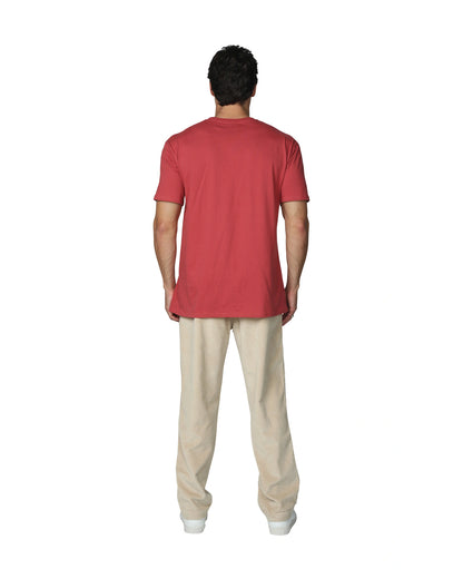 A full body back view of a male model wearing the the Okanui Mens Staple Tee in Rust colour paired with khaki corduroy pants and white shoes.