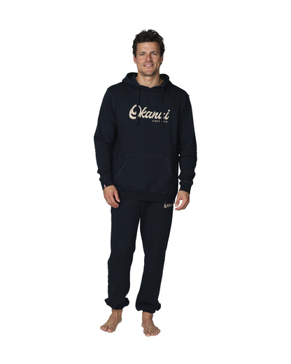 A full body front view of a male model wearing the Okanui Navy Signature Track Pants in Navy colour paired with a terno hoodie.