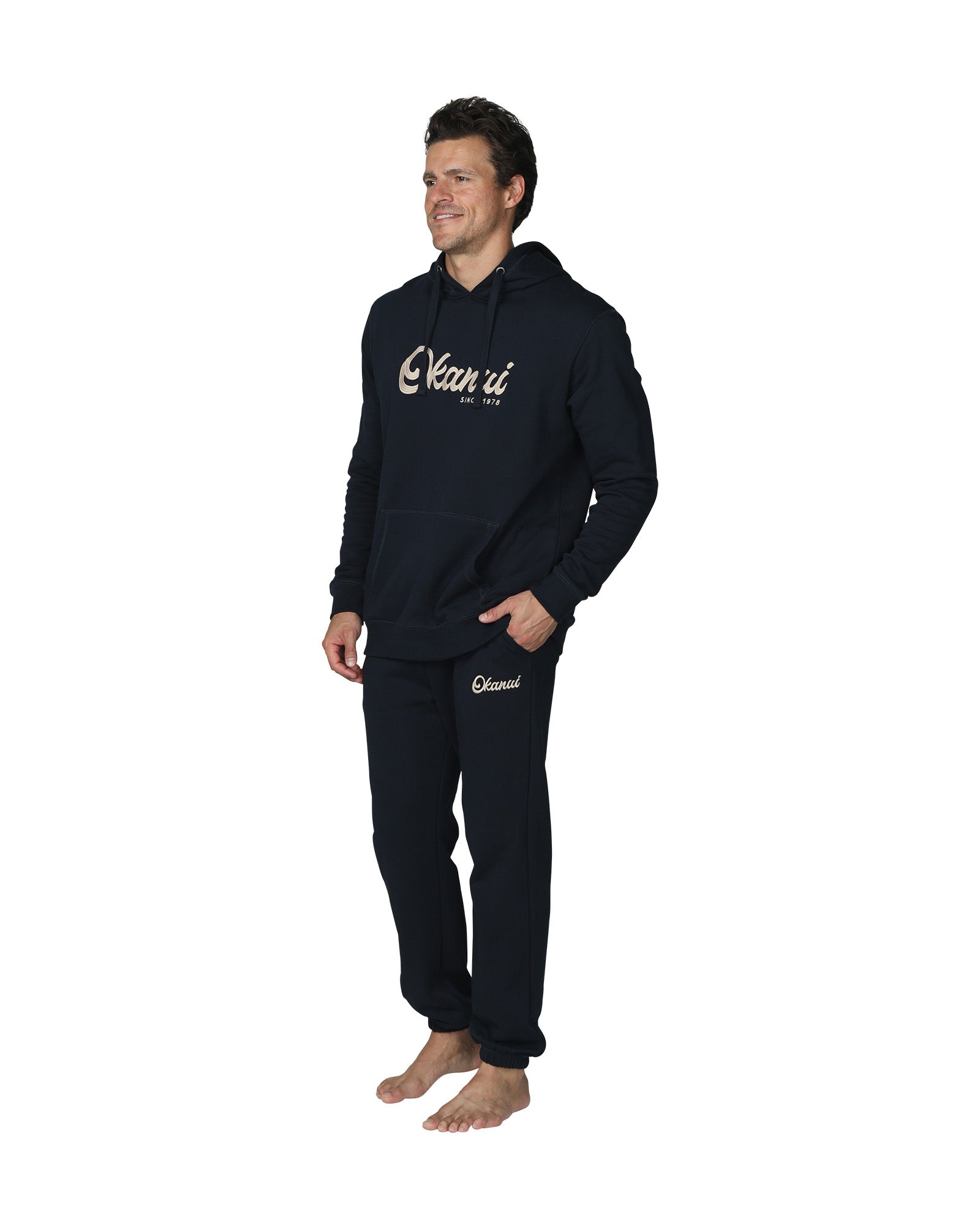 A male model wearing the Okanui Navy Signature Track Pants in Navy colour paired with a terno hoodie.