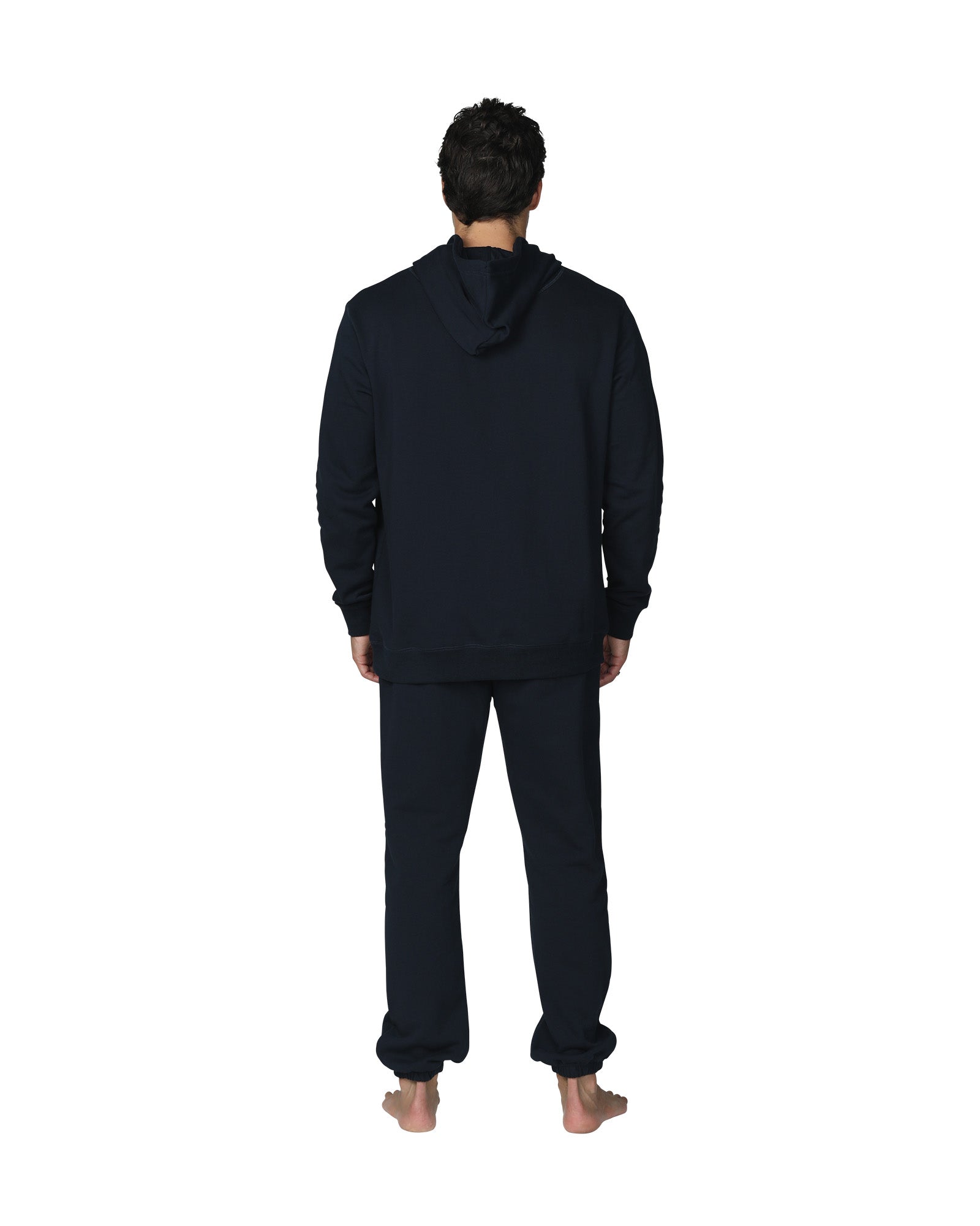 A full body back view of a male model wearing the Okanui Navy Signature Track Pants in Navy colour paired with a terno hoodie.