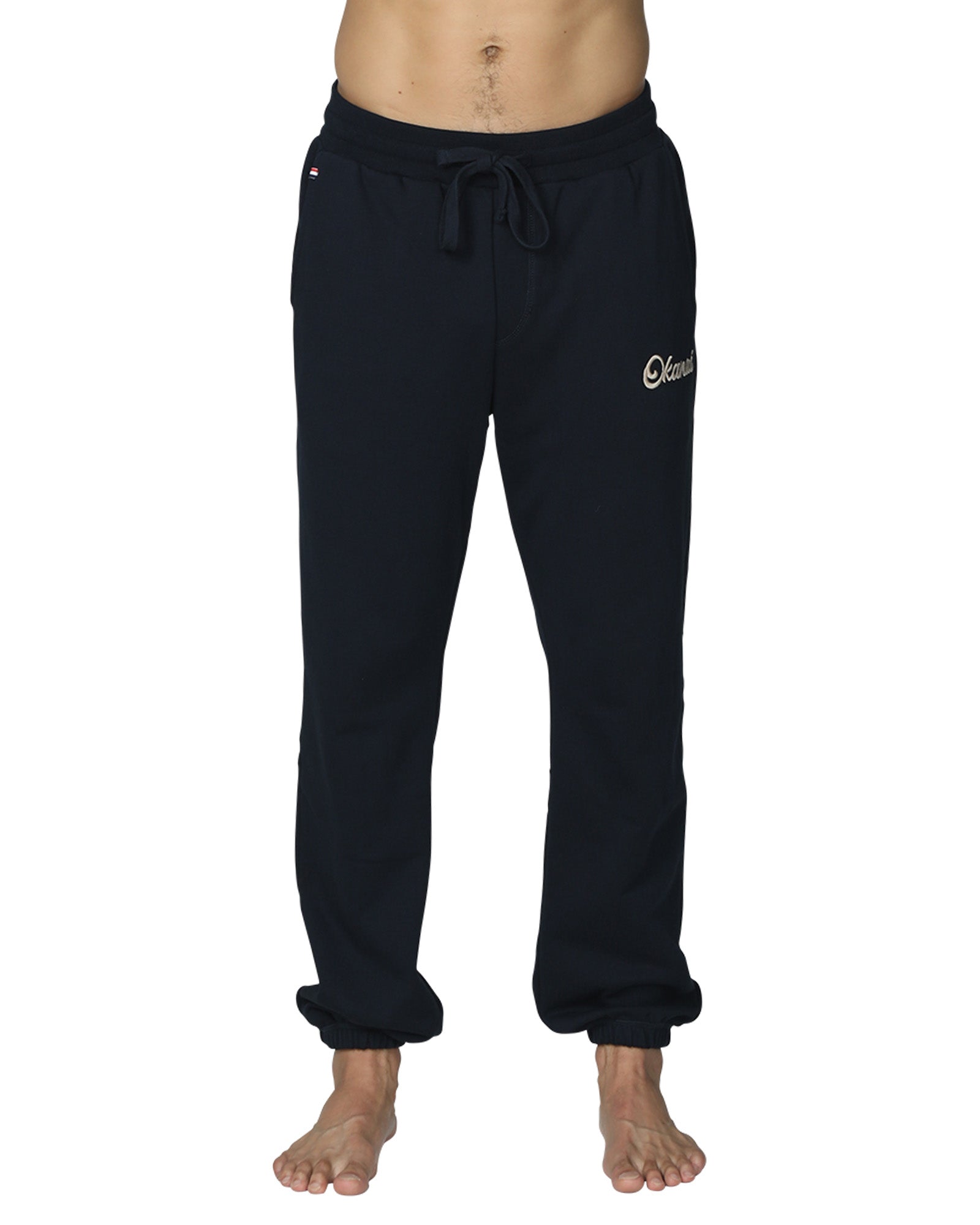 A close up front view of the Okanui Navy Signature Track Pants in Navy colour featuring an elastic waist and a drawcord.