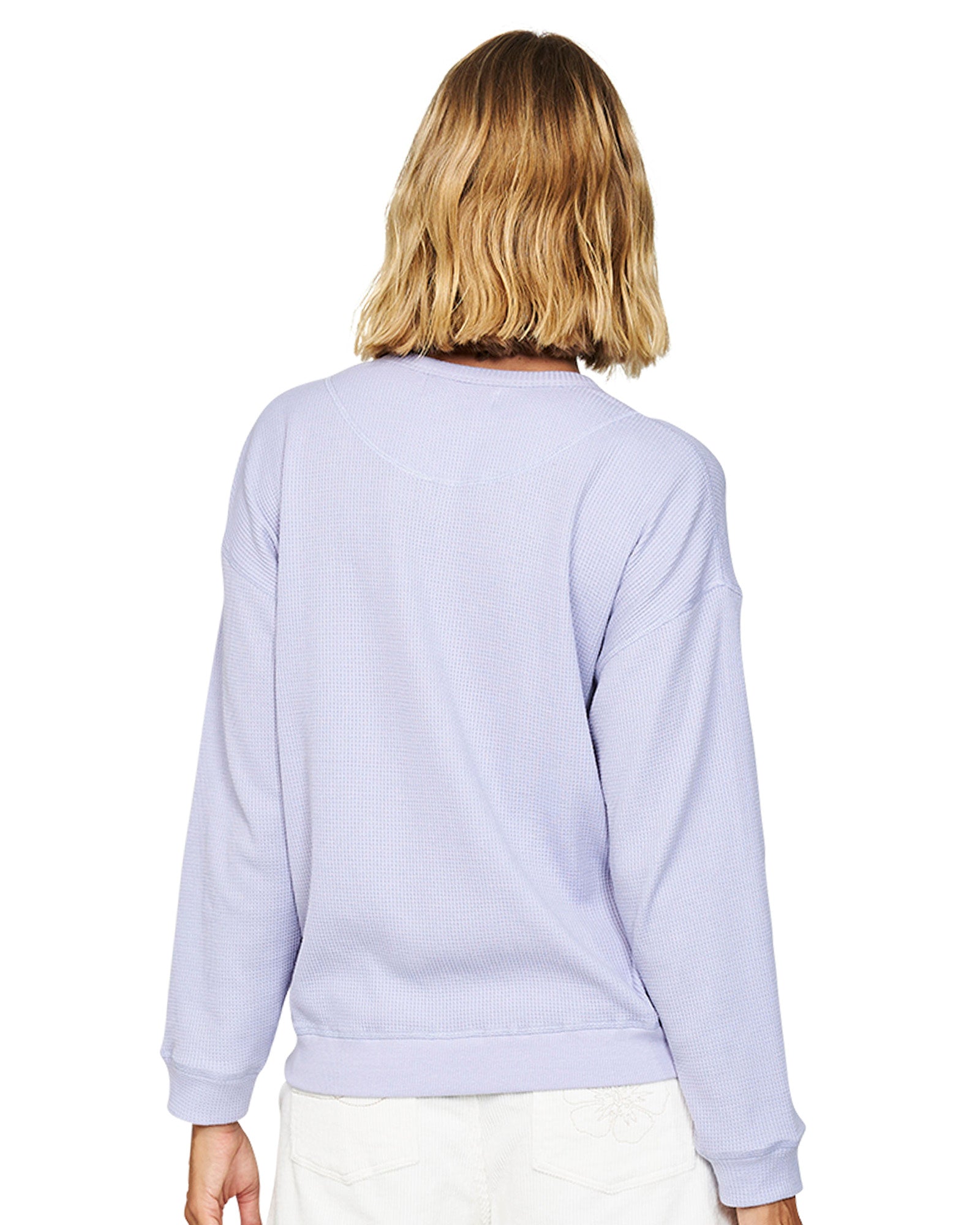 Back view of a blonde female model wearing the Okanui long sleeve waffle knit jumper in Gelato Lilac variant