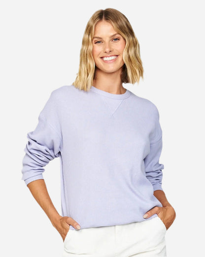 Two hands in pocket pose of a female model wearing the Okanui long sleeve waffle knit jumper in Gelato  Lilac variant