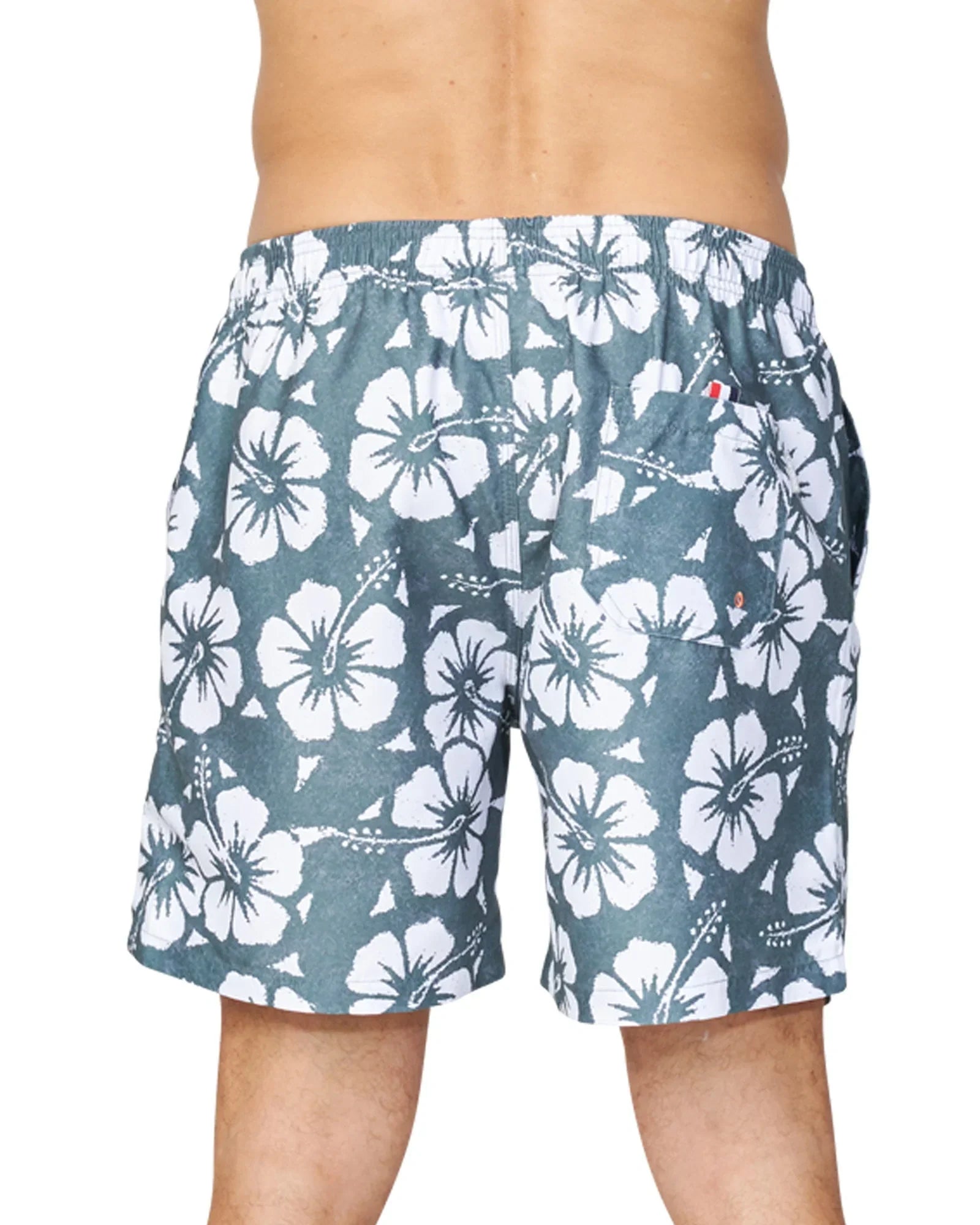 A closer half body back view of a male model wearing the Okanui Hibiscus Swimshorts in washed khaki colour.