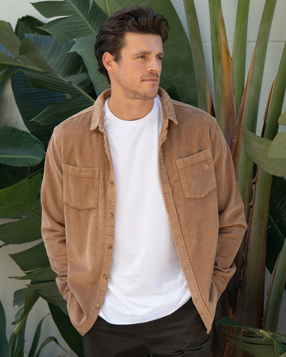 A front view of a male model wearing the Okanui Mens long sleeve corduroy jacket in sand