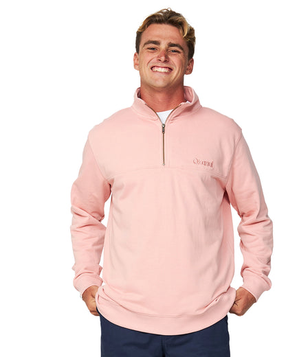 The Okanui Clubhouse Crew sweater in Dusty Pink color worn by a smiling model.