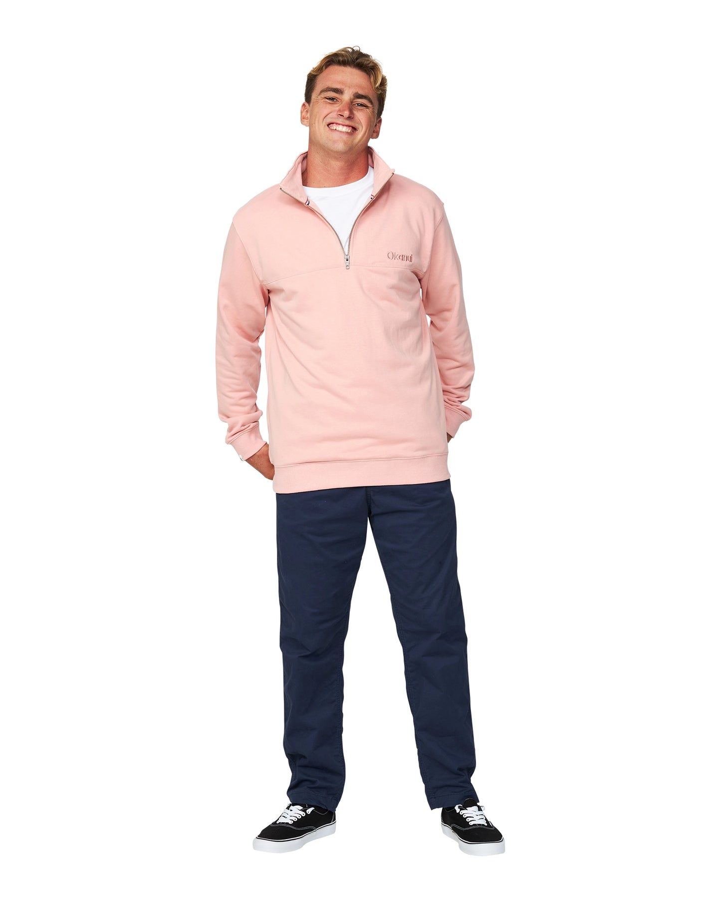 The Dusty Pink colour Okanui Clubhouse Crew Sweater worn by a smiling model with his hands behind his hip pose.