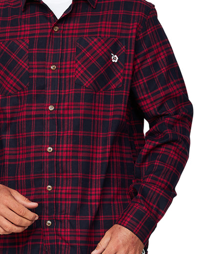 A closer look at the Okanui Long Sleeve Flannel Hiker Shirt emphasizing its red and navy pattern with two pattern contradicting pockets with a logo on the other.