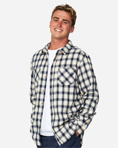 A male model posing wearing the Okanui Long Sleeve Flannel Hiker Shirt unbuttoned showing its versatility.