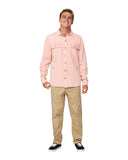 A male model smiling wearing the Okanui Deck Long Sleeve Shirt paired with khaki pants.