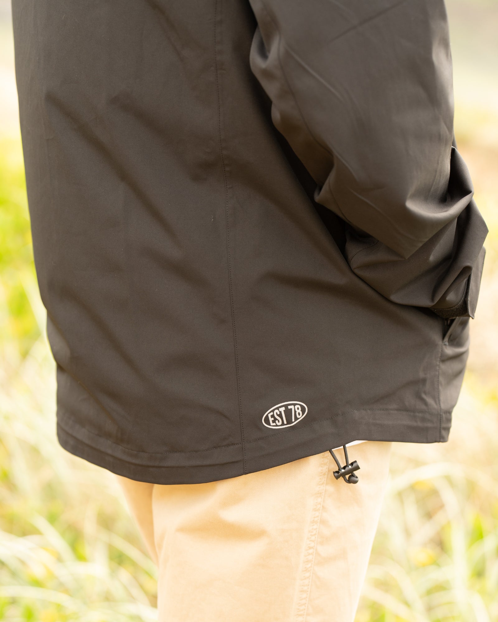 Mens surf jacket in black color with EST 78 logo on the lower back side. 