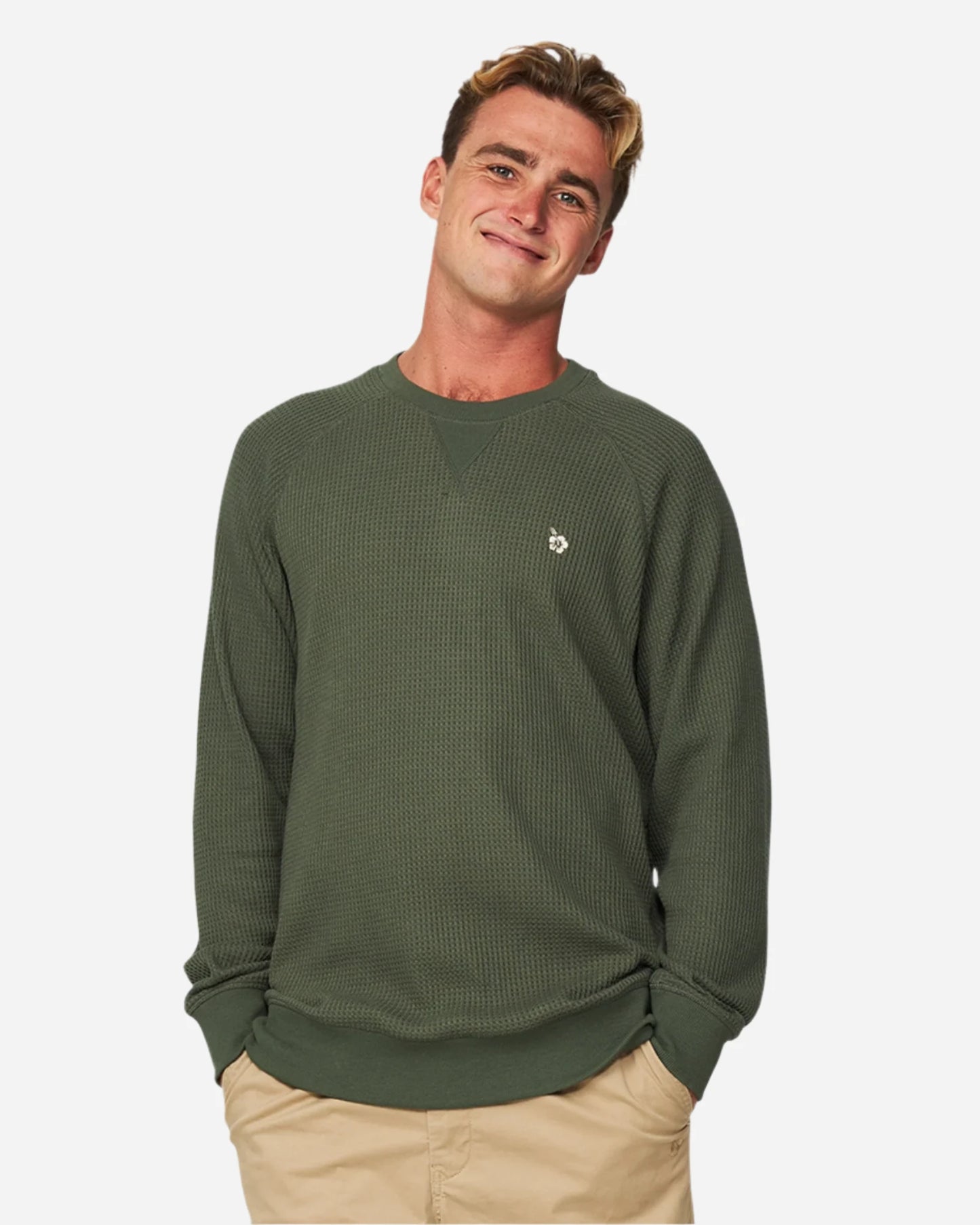 A smiling model with his hands in his pocket wearing a khaki pants and the Okanui Waffle Jumper Crew in Forrest Green colour.