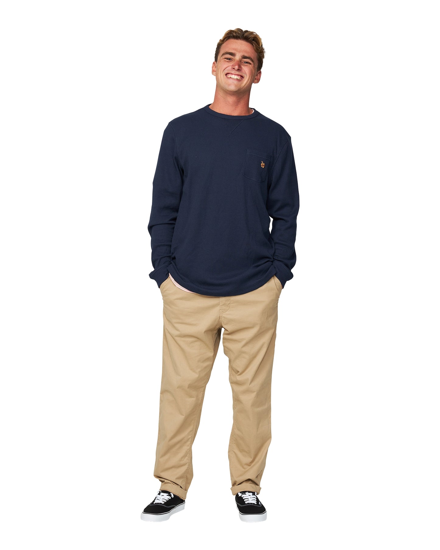 A male model wearing a loose fit khaki pants and the Okanui Long Sleeve Waffle Tee.