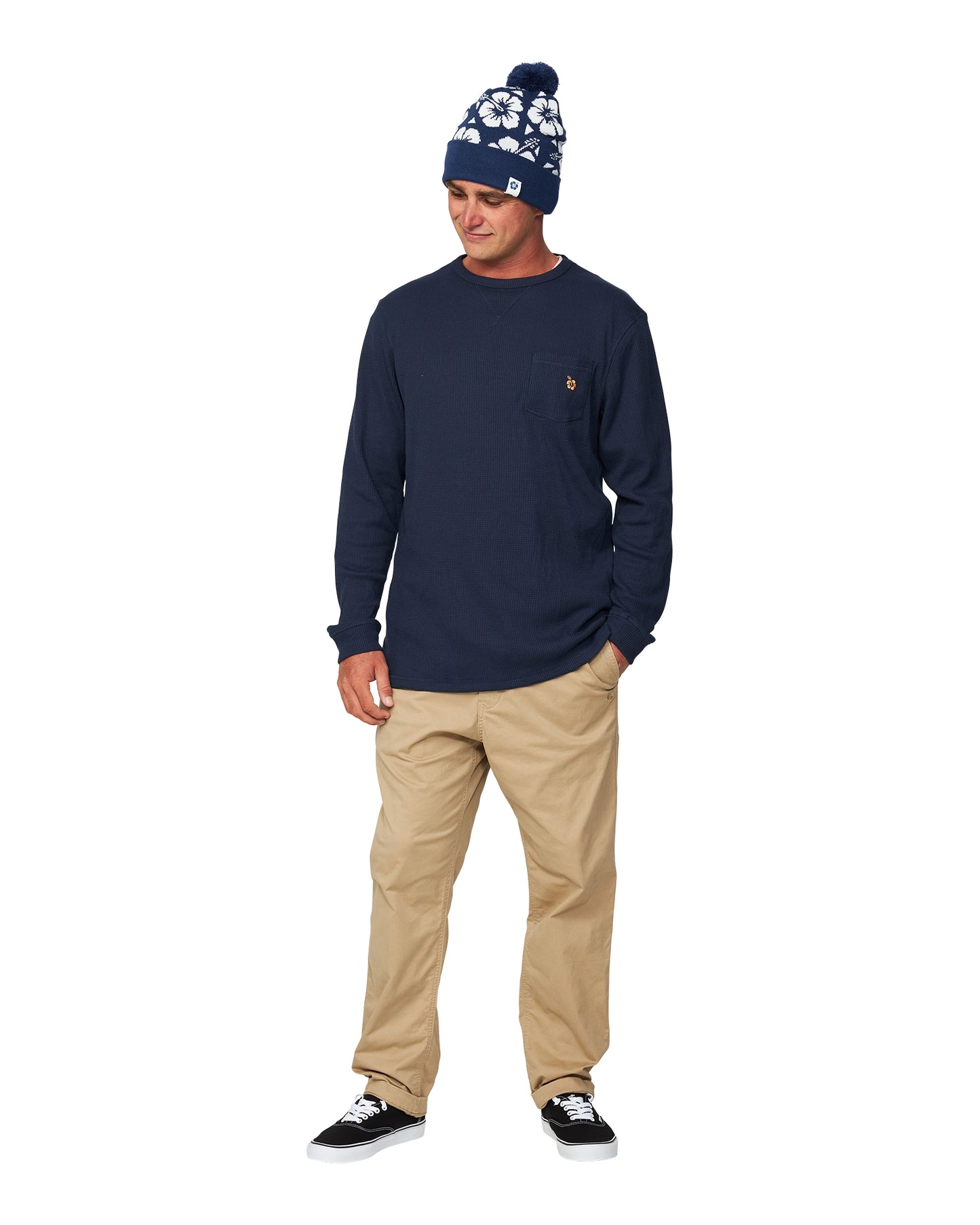 A male model wearing khaki pants and a bonnet with the Okanui Long Sleeve Waffle Tee.