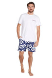 A classic white and navy hibiscus flower short shorts worn with a simple white top shirt with the Okanui logo displayed.