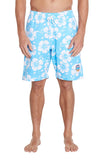 A person standing and wearing blue floral swim trunks with white flowers. The swim trunks have a drawstring at the waist and a small patch on the left leg. 