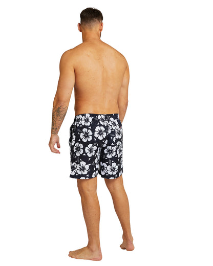 A back view of a male model wearing the Okanui Swimshorts in Hibiscus black.