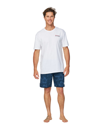 A male model wearing a white Okanui T-shirt paired with the Okanui Boardrider Boardshorts in navy colour.